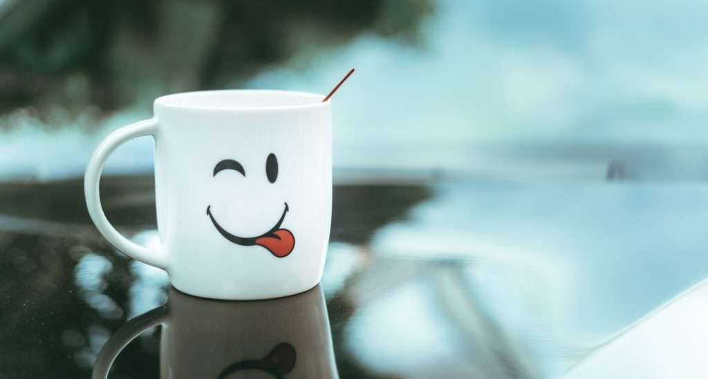 a coffee cup with a smiley face painted on it